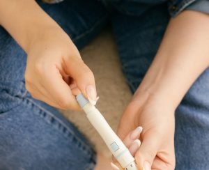 Woman using a GLP-1 weight loss injection pen for appetite management